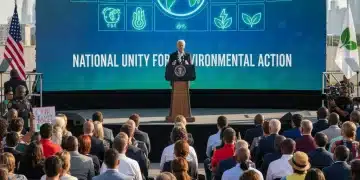 President Biden speaking on climate initiatives with renewable energy graphics